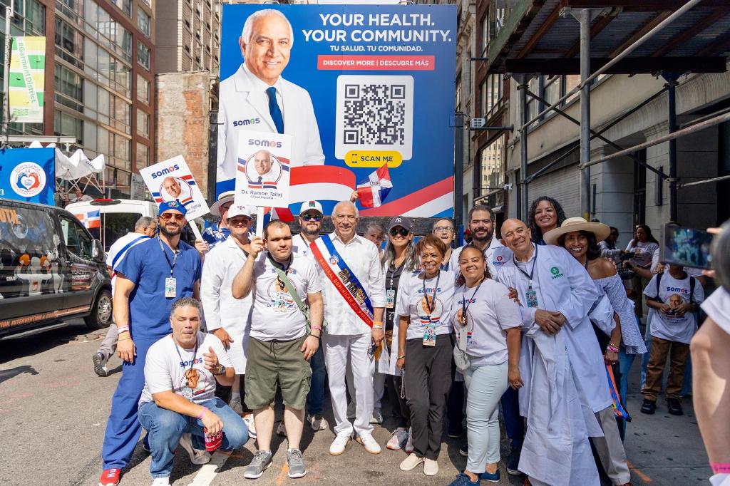 Un amplio equipo de SOMOS Community Care se unió al desfile para acompañar al doctor Ramón Tallaj, quien luce visiblemente feliz durante la celebración.